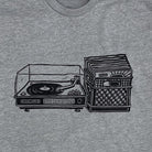 Close up of light grey shirt with black print of a record player with a milk crate full of records next to it. 