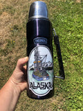 Alaska fishing boat sticker on water bottle held in hand.