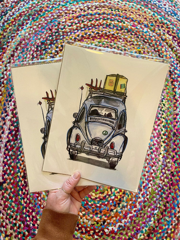 A hand holding two "Dog is My Copilot" art prints.