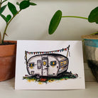 Greeting card printed with a colorful painting of a Boles Aero camper decorated with party flags, one of six designs in a set.