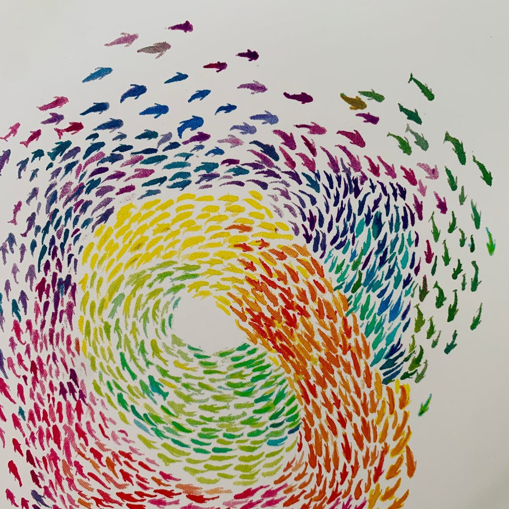 Detail of a greeting card printed with a rainbow-colored swirling school of fish.