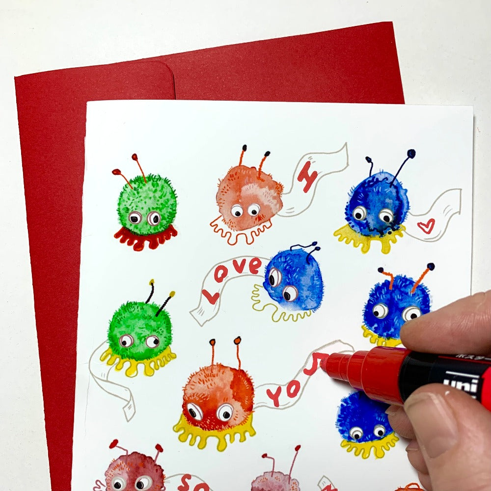 A greeting card printed with many colorful Weepuls - small fuzzballs with googly eyes and big feet.