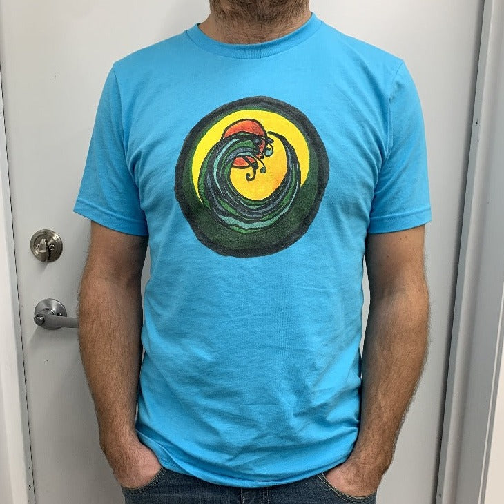 man wearing light blue t-shirt with a circle encompassing a wave and sun. Ink is yellow, orange, green and black