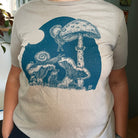 close up of woman wearing tan colored t shirt with blue ink of the full moon buffet slow loris t shirt.