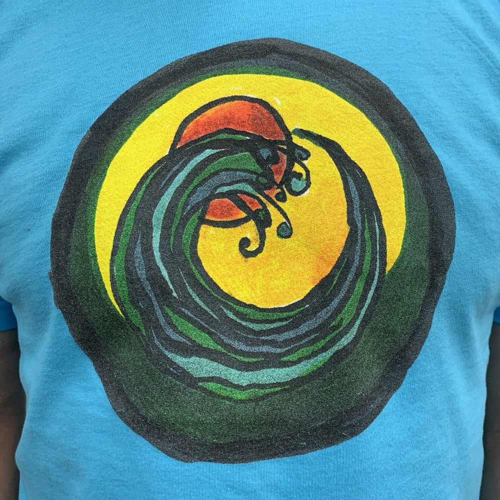 light blue t-shirt with a circle encompassing a wave and sun. Ink is yellow, orange, green and black