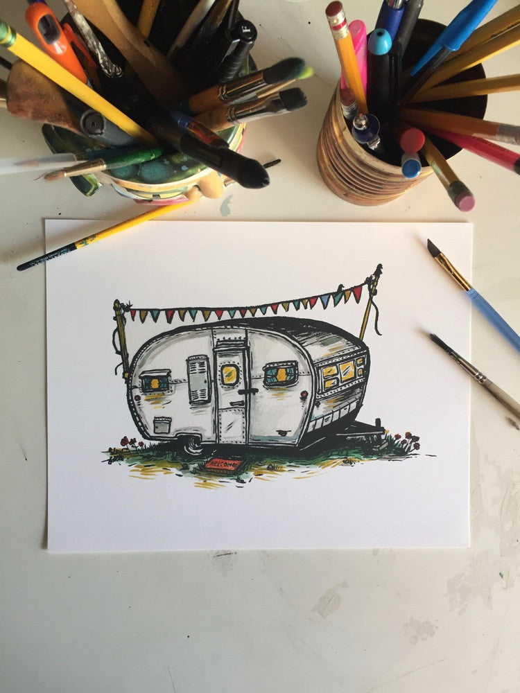 Original painting of a boles aero camper. Painting is flat on desk with brushes and pens nearby.