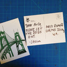 The front and back of a postcard printed with a two-tone green painting of the St Johns Bridge in Portland, Oregon.