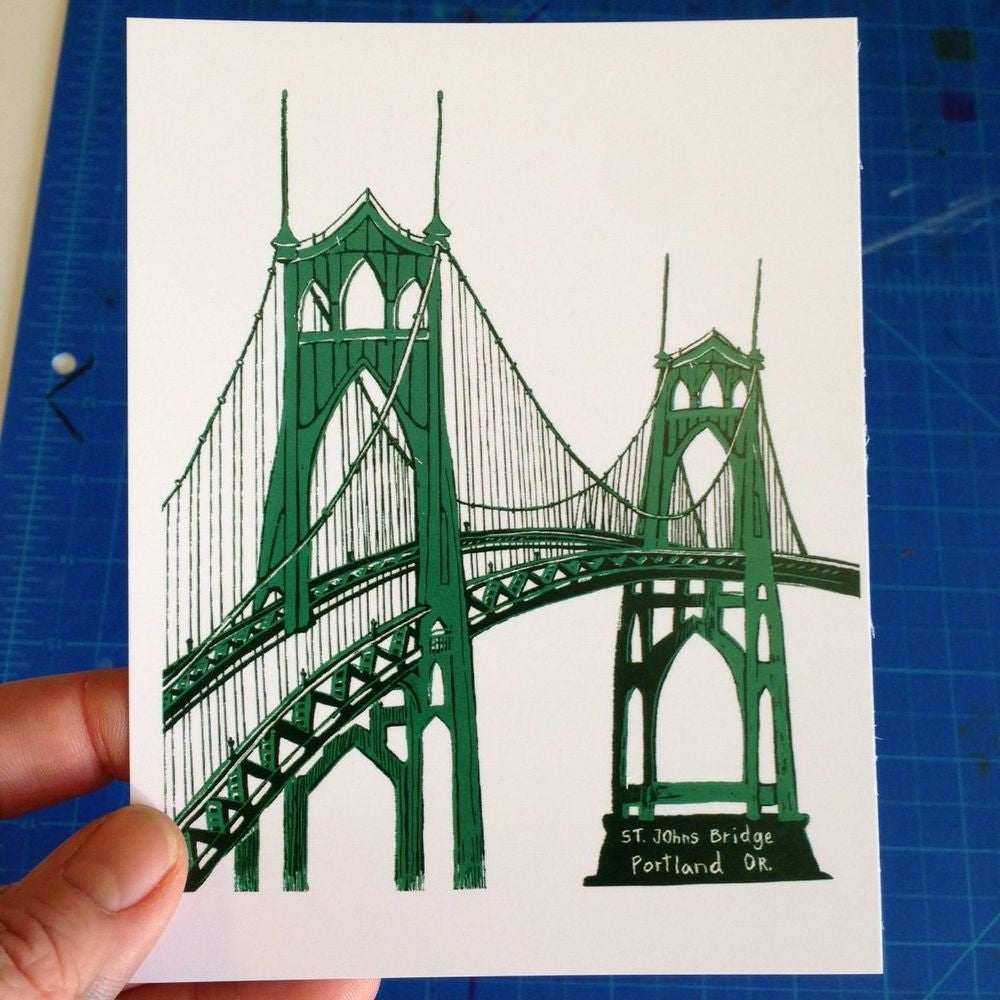 A postcard printed with a two-tone green painting of the St Johns Bridge in Portland, Oregon.