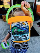 Colorfully painted sticker featuring marine landscape with words Anacortes, Washington underneath on child's toy beach bucket.