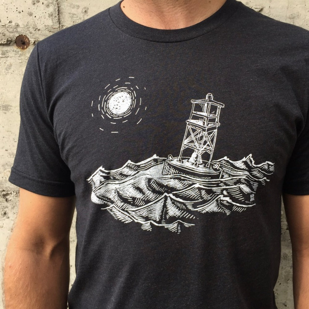 Man wearing black t-shirt with white ink of stormy seas and a rocking channel marker and a moon/sun in the distance.