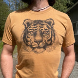 Unisex t shirt printed with a large tiger face, modeled on a man standing outside.